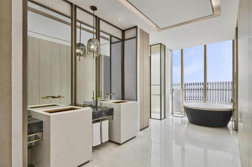 a bathroom with two sinks and a bath tub at Hyatt Regency Shanghai Pudong Lingang in Zhenghai