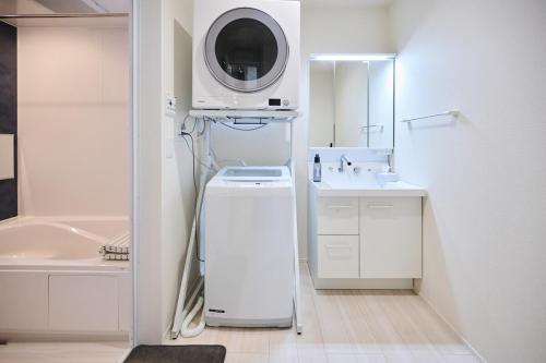 a bathroom with a sink and a washing machine at White Breeze House in Ginowan