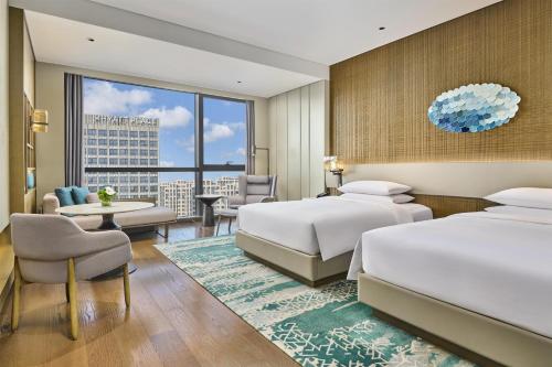 a hotel room with two beds and a living room at Hyatt Regency Shanghai Pudong Lingang in Zhenghai
