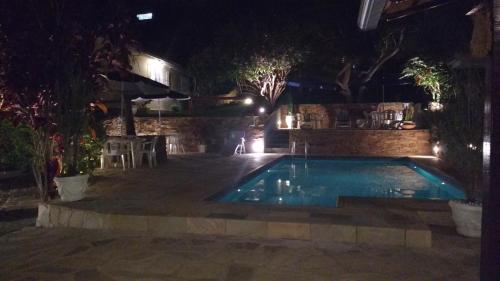 a swimming pool in a yard at night at 3 Palmeiras Guest Lounge in Miguel Pereira