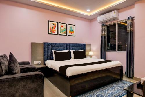 a bedroom with a large bed and a couch at Collection O SF Road Siliguri Formerly Jyoti Hotel in Siliguri