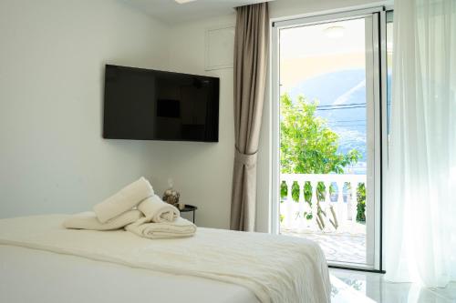 a bedroom with a bed with a television and a window at Stevovic Apartments - Brand New Apartments in Tivat