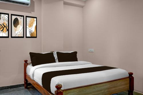 a white bedroom with a bed with black pillows at Hotel O Chikkabanavara Lakeview Bangalore Formerly Bvk Residency in Bangalore
