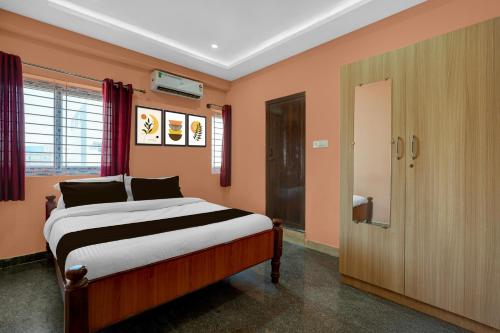 a bedroom with a large bed and a door at Hotel O Chikkabanavara Lakeview Bangalore Formerly Bvk Residency in Bangalore