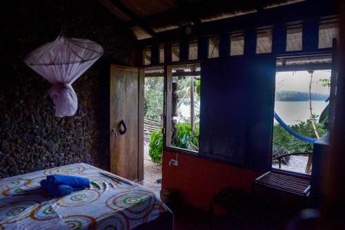 a bedroom with a bed and a view of a lake at Saldomar B&Biosphere in Bubaque