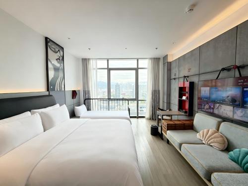 a hotel room with a large bed and a couch at SSAW Yintai Boutique Hotel Qiandao Lake in Chun'an