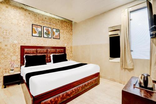 a bedroom with a large bed and a window at Collection O Kalka Ji Formerly Hotel Gera in New Delhi