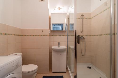 a bathroom with a toilet and a sink and a shower at Apartament Piastowska Elite in Gdańsk
