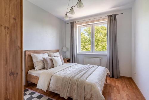 a bedroom with a large bed and a window at Apartament Piastowska Elite in Gdańsk