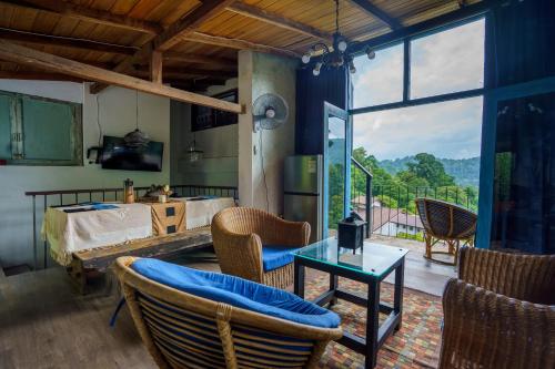 a living room with a table and chairs and a television at Kandyan Mist Retreat in Kandy