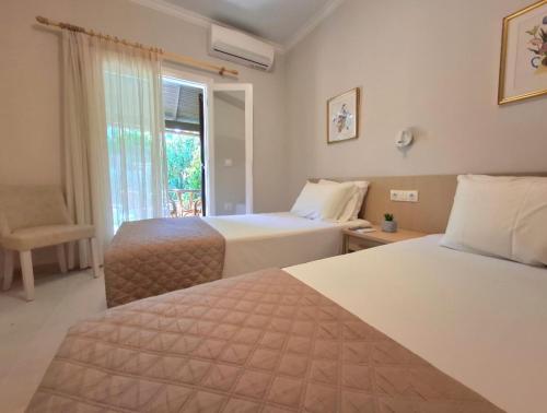 a hotel room with two beds and a window at Villa Tina Country Beach Apartments in Acharavi