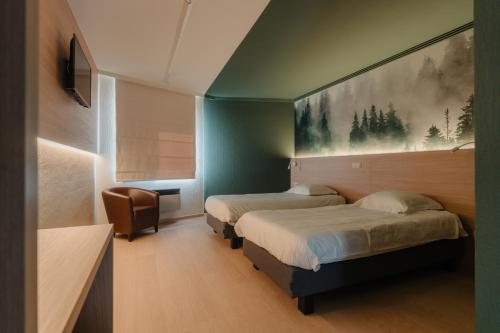 ein Schlafzimmer mit zwei Betten und einem Gemälde an der Wand in der Unterkunft Hotel Saint-Hubert in Malmedy