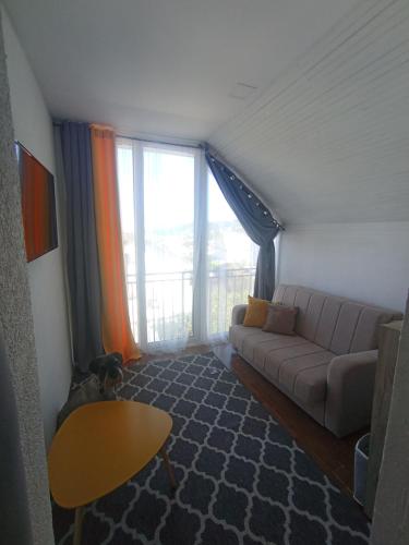 ein Wohnzimmer mit Sofa und großem Fenster in der Unterkunft Арartment IRENA in Dobra Voda
