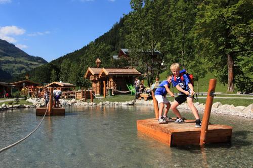 two boys standing on a wooden platform in the water at Appartements Wirnsperger in Grossarl