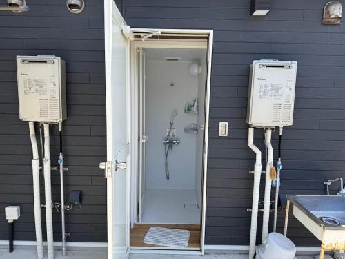 a bathroom with a shower and a toilet and a sink at Guest House Goofy in Hyuga