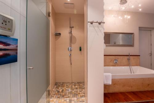 a bathroom with a tub and a shower and a sink at Premium Apartments Faselehof in Marlengo