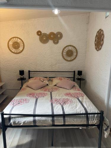 a bedroom with a bed with pillows and clocks on the wall at STUDIO Havre de paix au pont du gard Piscine et Jacuzzi chez Valerie Payre in Vers Pont du Gard