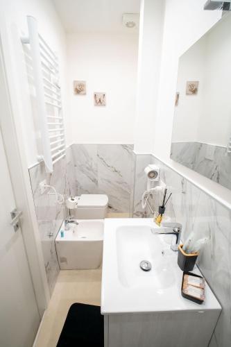 a white bathroom with a sink and a toilet at Luxury Apartment Da Giovanni in Caserta