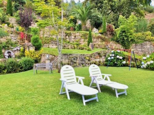 two chairs sitting in the grass in a garden at Casa Turistica Nigrán in Nigrán