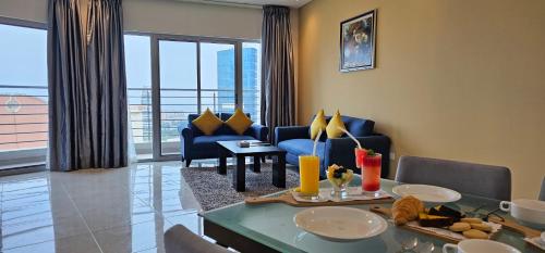a living room with a blue couch and a table at Loumage S Suites and Spa in Manama