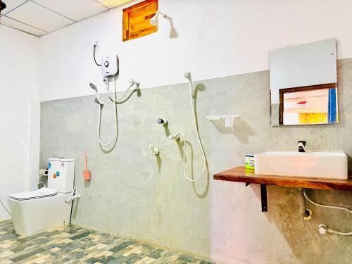 a bathroom with a shower and a toilet and a sink at Another World in Arugam Bay