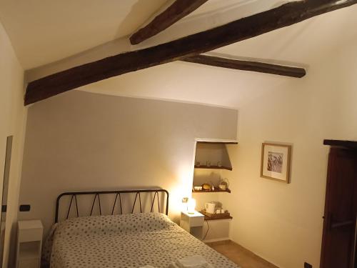 a bedroom with a bed and wooden beams at Casa di Ruggi in Tenaglie