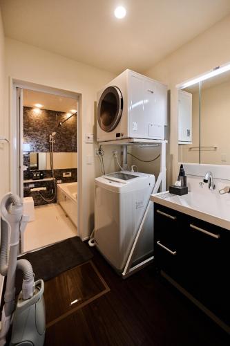 a kitchen with a sink and a microwave at Black Grove House in Ginowan