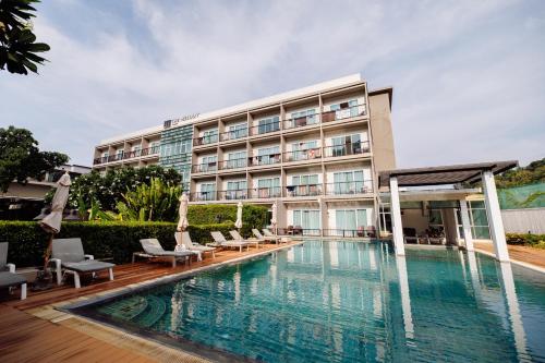 a hotel with a swimming pool in front of a building at The Melody Phuket Kata Beach in Kata Beach