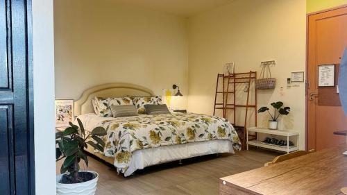 a bedroom with a bed and a plant in it at Halo Bonjour Perch in Ban Chuang