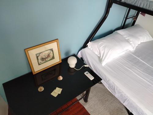 a bedroom with a bed and a table with a picture at Blu Corner in Lian