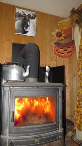 a stove with a fire in a room at Le Gîte Ambrelane in Thetford Mines