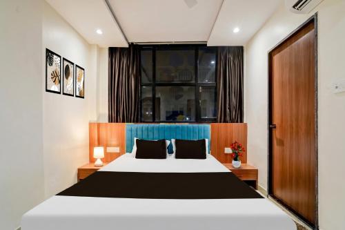 a bedroom with a large white bed and a window at Hotel O Mahakal Temple Formerly Shivangam in Ujjain