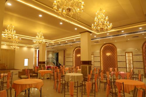 a banquet hall with tables and chairs and chandeliers at Sona Pristine Hotel And Resort Ambala in Dhūlkot