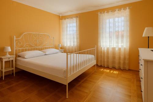 a bedroom with a white bed and two windows at Apartment Andrea in Mirce