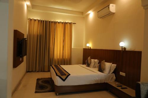a hotel room with a bed and a television at Sona Pristine Hotel And Resort Ambala in Dhūlkot