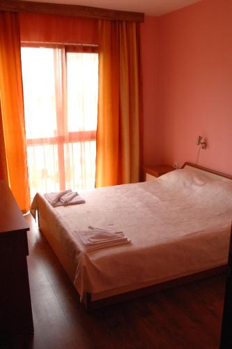 a bedroom with a bed and a large window at Condo Hotel Valentina in Obzor
