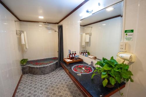 a bathroom with a tub and a sink and a mirror at Okay Boutique Hotel in Phnom Penh