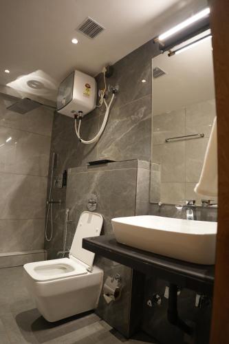 a bathroom with a toilet and a sink at Trevon Twin Tree Inn in Dhanbād