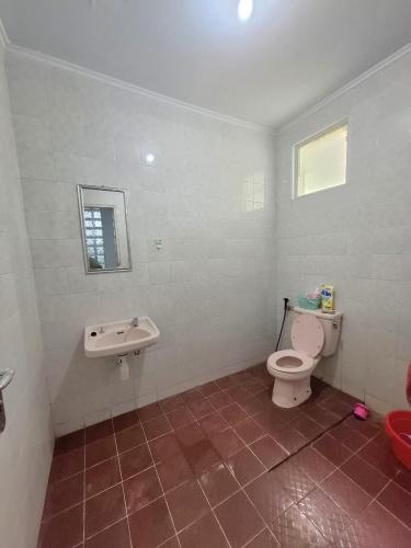 a bathroom with a toilet and a sink at Palm Cozy Villa 4 in Pasauran