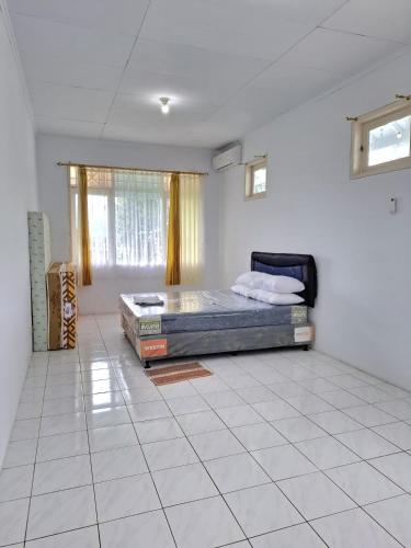 a bedroom with a bed in the middle of a room at Palm Cozy Villa 4 in Pasauran