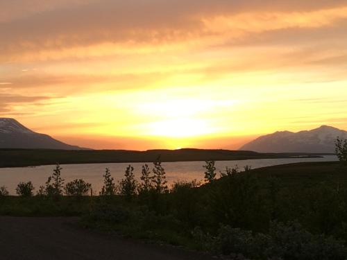 a sunset over a lake with mountains in the background at Aurora Vacation Homes Fagravik in Akureyri