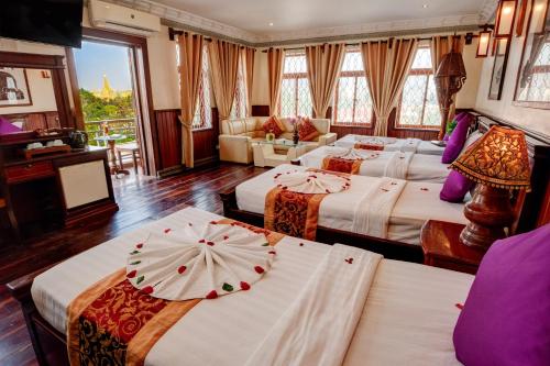 a hotel room with three beds with an umbrella on them at Okay Boutique Hotel in Phnom Penh