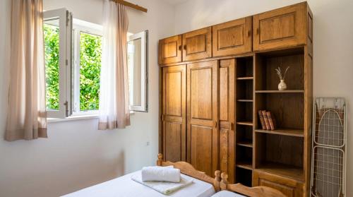 a bedroom with a wooden cabinet and a bed and a window at Happy 2Bedroom Apartments in Gornji Karin