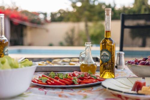 a table with a bottle of oil and plates of food at Casa Rural Villa Arcadia in Corvera
