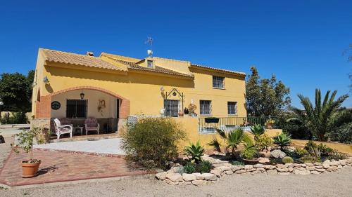 a large yellow house with a patio in front of it at Casa Rural Villa Arcadia in Corvera