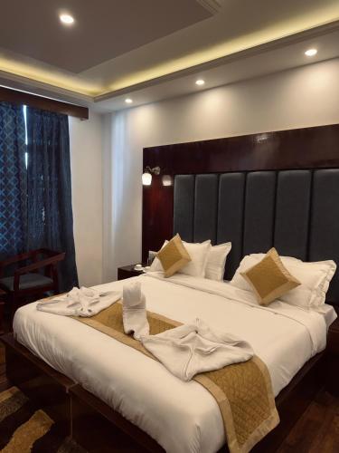 a bedroom with a large bed with white sheets at The Grand K2 Hotel in Leh