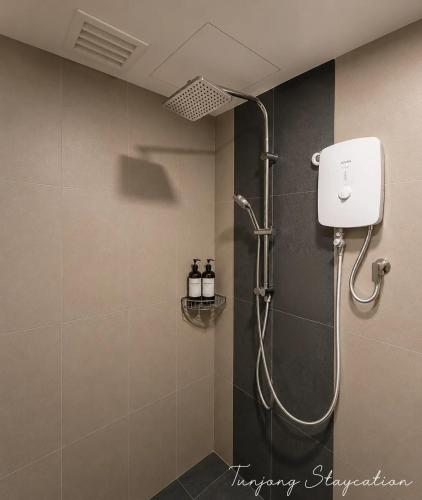 a shower with a shower head in a bathroom at Tunjong Stay in Kota Bharu