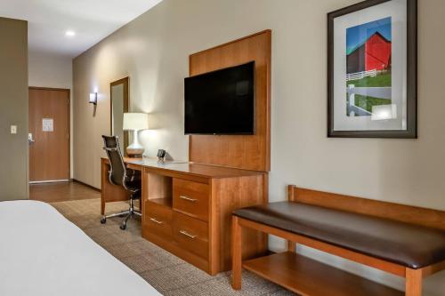 a hotel room with a desk and a tv at Comfort Suites Hotel and Conference Center in Berlin
