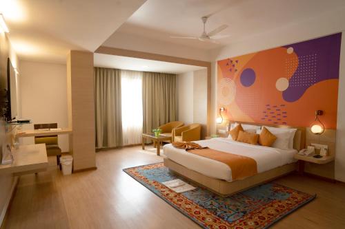 a hotel room with a large bed and a desk at IRA By Orchid Bhubaneswar in Bhubaneshwar