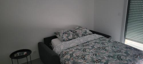 a bedroom with a bed and pillows and a window at L'Appar-TMN in Challans